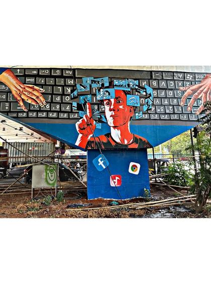This bridge mural comments on our relationship with social media and the digital world. The artwork features a keyboard, social media icons, and a person at the center of it all.