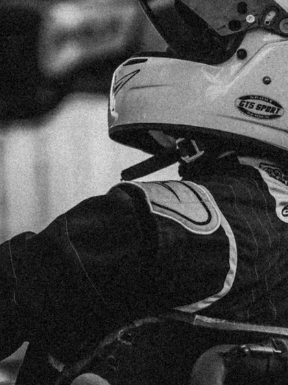A black and white shot of a driver in his kart, capturing the timeless focus of a racer.