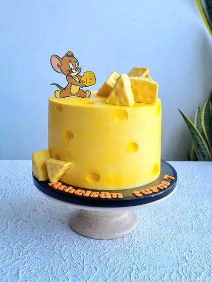 A fun Tom and Jerry cake, designed to look like a big block of Swiss cheese. I teach how to create the cheese texture and holes in the buttercream.