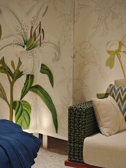 The finished collaborative mural, "A Walk in my Garden," installed at an exhibition. The piece combines painted lilies with delicate line drawings and sculptural eyes.