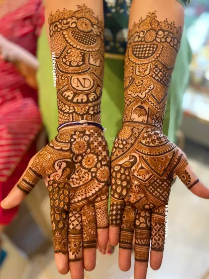 A gorgeous, intricate Indian mehndi design perfect for a wedding guest or siders. It features a personalized initial 'N', an elephant motif, and dense traditional patterns.