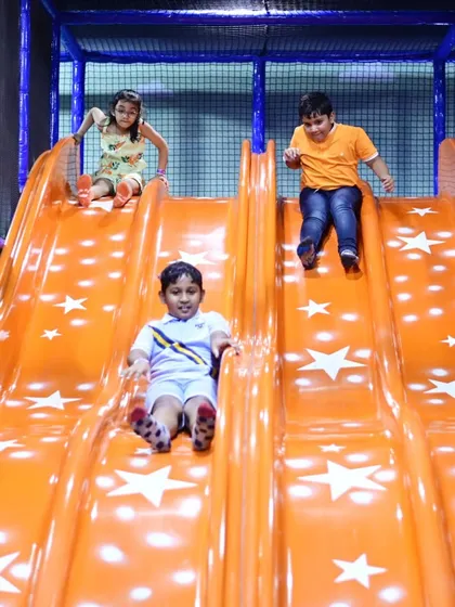 Three friends enjoying the star-themed slide together. It's the perfect spot for creating fun memories with friends.