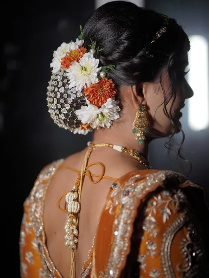 A detailed view of the floral hair bun, adorned with a traditional net accessory.
