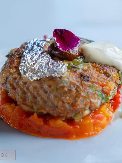 A close-up of the Mutton Gilafi, showcasing the delicate garnish and the glistening edible silver leaf. This is a dish that delights the eyes as much as the palate.