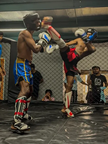 Our training is relentless because the fight demands it. Here, one of our fighters executes a powerful high kick during an in-house kickboxing tournament, a testament to the striking skills we build.