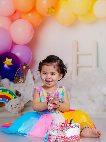 The joy on her face says it all. This shot captures the moment she realizes the cake is all for her, surrounded by a pastel rainbow of balloons.