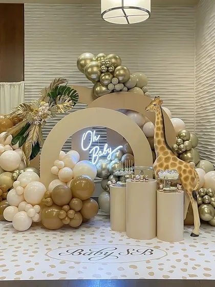 This "Oh Baby" safari-themed baby shower is one of our most popular designs. I combined neutral-toned balloons with gold accents, a custom neon sign, and a life-sized giraffe prop to create a chic and playful atmosphere.