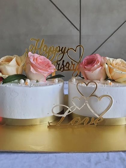 A close-up of the anniversary cakes, showing the 'Love' topper and geometric chocolate hearts.