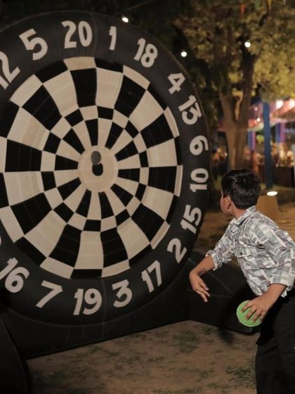 An inflatable dart board game set up for an outdoor carnival party, providing fun for kids and adults alike.