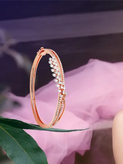 The eternal gleam of diamonds meets the warmth of rose gold in this delicate bridal kada. The design features a leaf-like motif of marquise diamonds, creating a fusion of beauty that whispers sophistication.