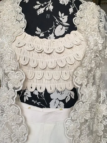A close-up of the scalloped, textured blouse and the hand-embroidered jacket. This outfit is a true head-turner.