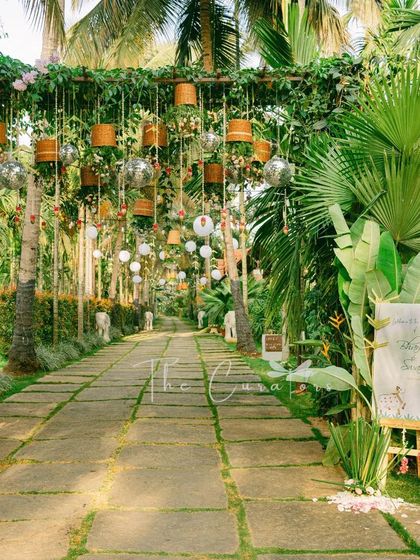 A personalized welcome sign nestled in lush tropical foliage, setting a natural and organic tone for the wedding ceremony.