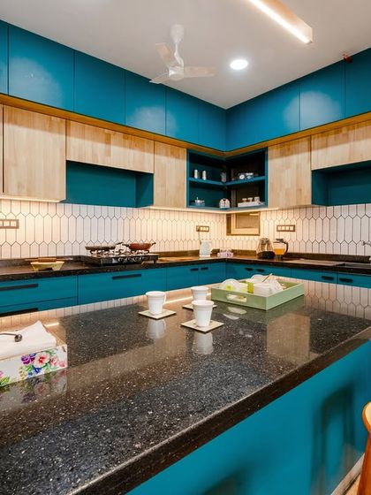 A view of the kitchen showing the full layout, including the refrigerator, ample cabinet space, and the central breakfast bar.