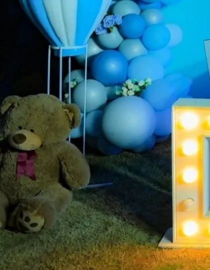 A close-up of the decor for Daksh's party, showing the large teddy bear and light-up '1' that were part of the outdoor setup.