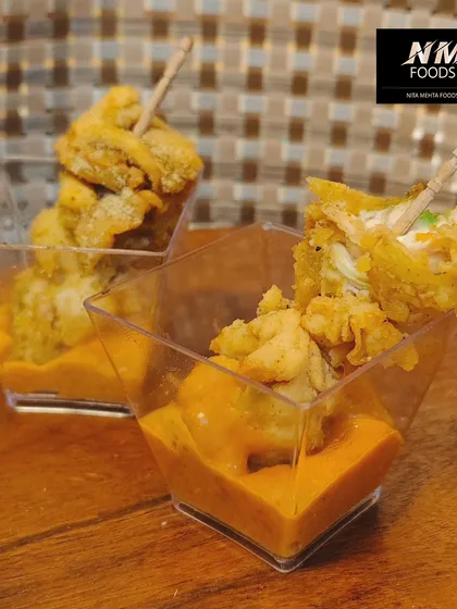 Crispy fried bites served in a shot glass with a creamy dipping sauce at the bottom. This presentation keeps the appetizer crisp and makes it easy for guests to enjoy.