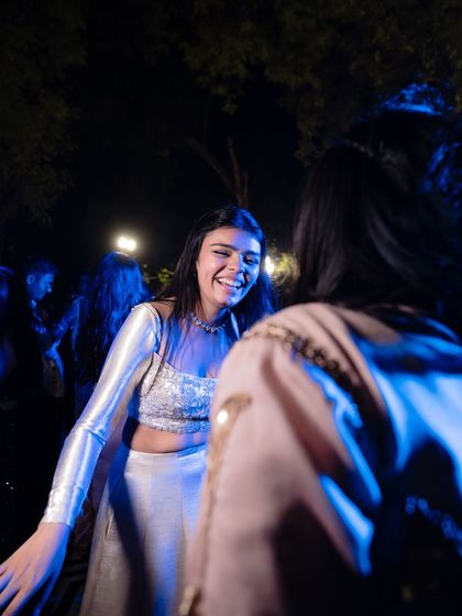 A candid moment of the bridesmaid laughing with a friend. We believe the best outfits are the ones you can truly live and make memories in.