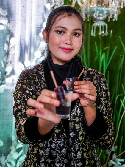 A guest holding up our popular Jamun flavored ice golas. A perfect blend of traditional flavor and modern presentation.