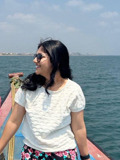A happy client enjoying the sea breeze and the beautiful view of the Chennai coastline during her boat ride.