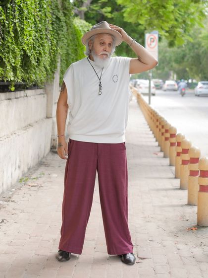 Street style photography featuring a senior model. This shot captures a natural, confident stance on a city sidewalk, proving style has no age limit.