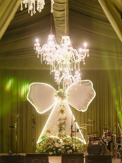 The centerpiece of the "Big Bow Affair" was this dramatic stage. A giant illuminated bow, framed by elegant green draping and sparkling chandeliers, created a show-stopping backdrop for the evening's performances.