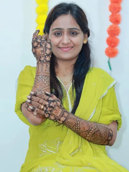 A classic pose, with the bride's mehendi-adorned hands framing her happy face.