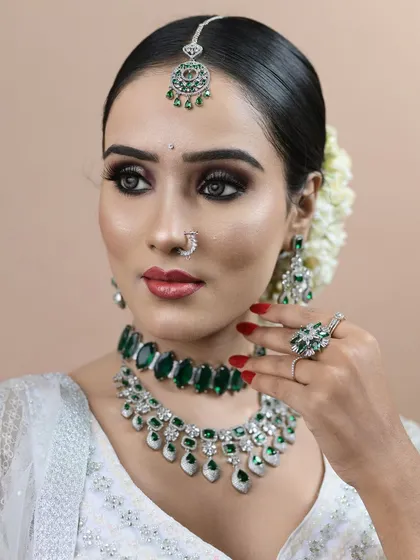 The makeup is bold yet elegant, with smokey eyes and perfectly defined features, all achieved with airbrush techniques.