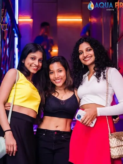 Friends posing for a photo on the stairs at The Fixx Bar. The club's unique design offers many cool spots for pictures.