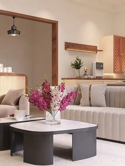 From this angle, you can see the open layout connecting the living area to the dining space. The vertically pleated sofa and smooth, curved chaise lounge add textural interest to the minimalist design.
