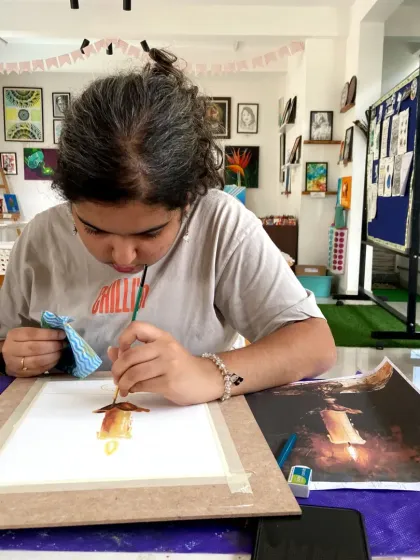 A student adds the final touches to a glowing candle painting in our acrylics short-term course. We explore various subjects, including still life and landscapes.