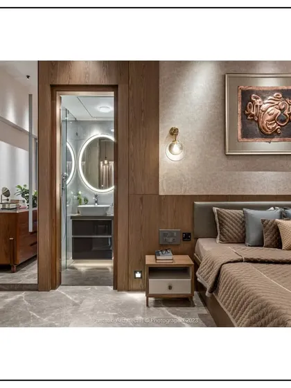 We believe in creating seamless transitions between spaces. This master bedroom is designed as a personal sanctuary, with warm wood paneling and soft lighting that flows directly into an elegant, modern ensuite bathroom, crafting a cohesive and luxurious private retreat.