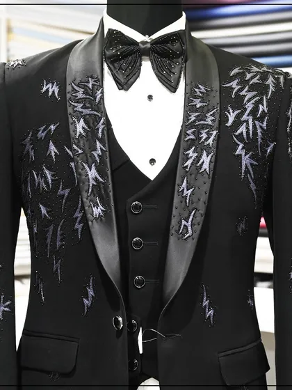 A closer view of the embroidered tuxedo, showing the detail of the threadwork on the lapels and shoulders.