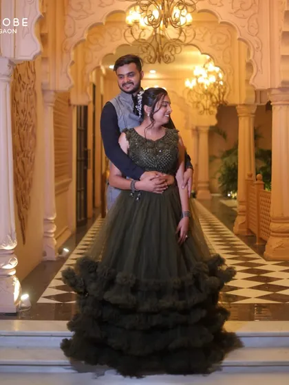 A romantic shot of the couple. The olive green lehenga with its dramatic ruffles creates a beautiful silhouette.