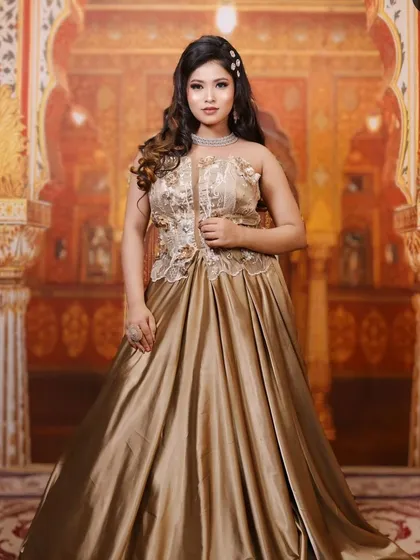 A model wearing an elegant golden satin gown with an embroidered bodice. This is a perfect, hassle-free option for a wedding guest or for a pre-wedding shoot.