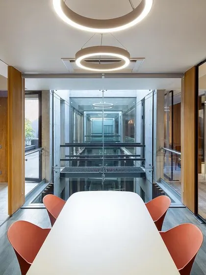 This meeting room at the Laxcon office is designed with full-height glass walls overlooking the central atrium, promoting a culture of transparency and connection.