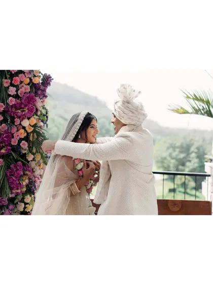 A candid moment during the ceremony, with the couple sharing a laugh. This shows that even solemn rituals can be filled with moments of lightheartedness and personal connection.