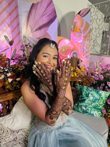 A playful and happy bride winking for the camera, showing off her detailed bridal mehndi. Her joy is infectious!