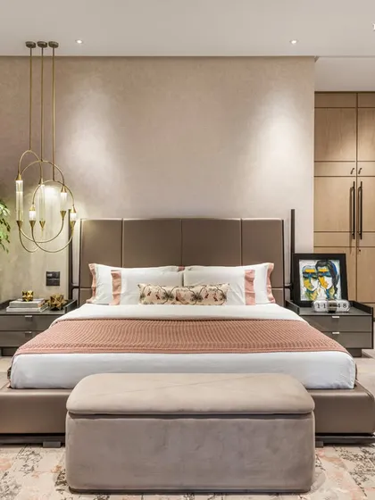 A frontal view of the primary bedroom, where earthy tones and pastel highlights speak of understated sophistication. The centerpiece bed is accented with pastel tones, contrasting beautifully against the muted palette of the room and a sleek, modern wardrobe.
