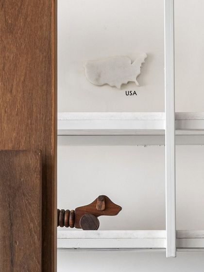 A close-up from the 'On The Grid' office reveals the thoughtful details we integrate. A custom wooden door handle, textured waffle glass, and a playful marble cutout of the USA on the shelf all contribute to the space's unique, travel-inspired narrative.
