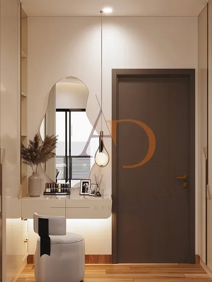 An elegant dressing area within the bedroom, featuring a floating vanity with a backlit, organically shaped mirror and a stylish pendant light.