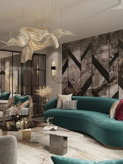 Another view of the living room with a geometric marble wall and a curved teal sofa. This angle shows the glass partition that separates the space, adding an element of modern sophistication.