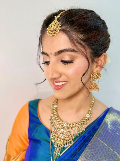 A close-up profile highlighting the soft, romantic hairstyle and the delicate shimmer on her eyelids. The skin has a beautiful, natural-looking glow.