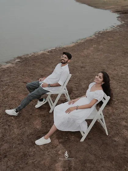 A duplicate of 295, showing a minimalist and artistic shot of the couple relaxing in chairs by the lakeside on an overcast day.