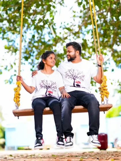 A classic romantic pose on a swing. The couple's matching t-shirts and the simple, natural setting make for a sweet and timeless photo.