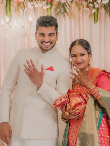 The big moment! The newly engaged couple proudly shows off their rings to the camera, their smiles radiating pure joy.