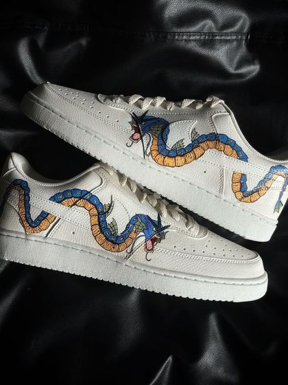 A pair of Nike Court Vision sneakers customized with a wrap-around design of the Pokémon Gyarados.