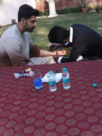 Our tattoo artist is seen here working at an outdoor corporate event, providing a fun and relaxing activity for employees.