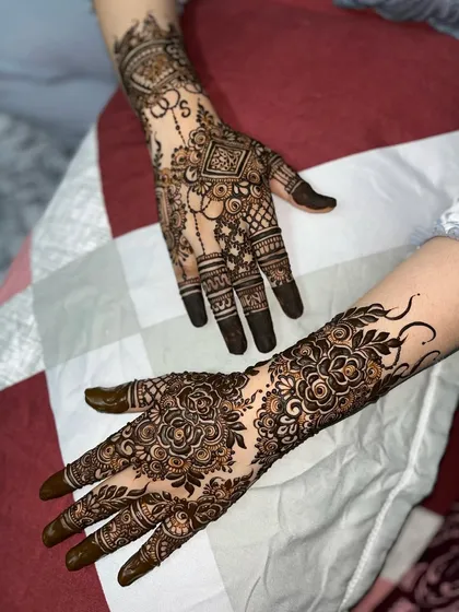 A beautiful pairing of two different styles: one hand with a geometric design and the other with a dense floral pattern.