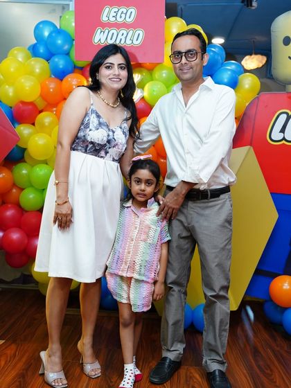 A family portrait in front of a vibrant Lego-themed backdrop. We can combine themes, like adding a Spider-Man appearance to a Lego party, to create a truly custom event.