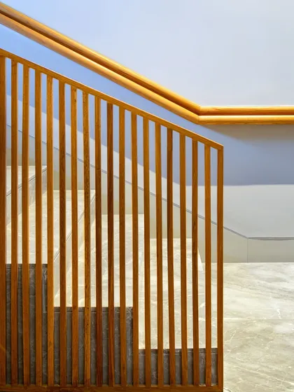 The "in-between" spaces are just as important as the main rooms. This staircase, with its clean lines and warm wooden slat railing, is an example of how we intentionally design transitional areas to connect people and floors with simple elegance.