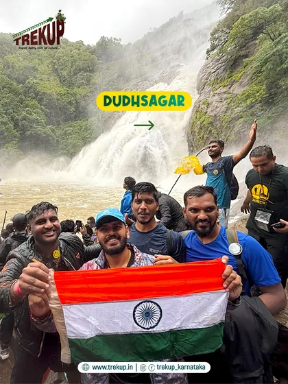 A group of our trekkers celebrating at the base of Dudhsagar falls, holding the Indian flag with pride. The sense of achievement is incredible.